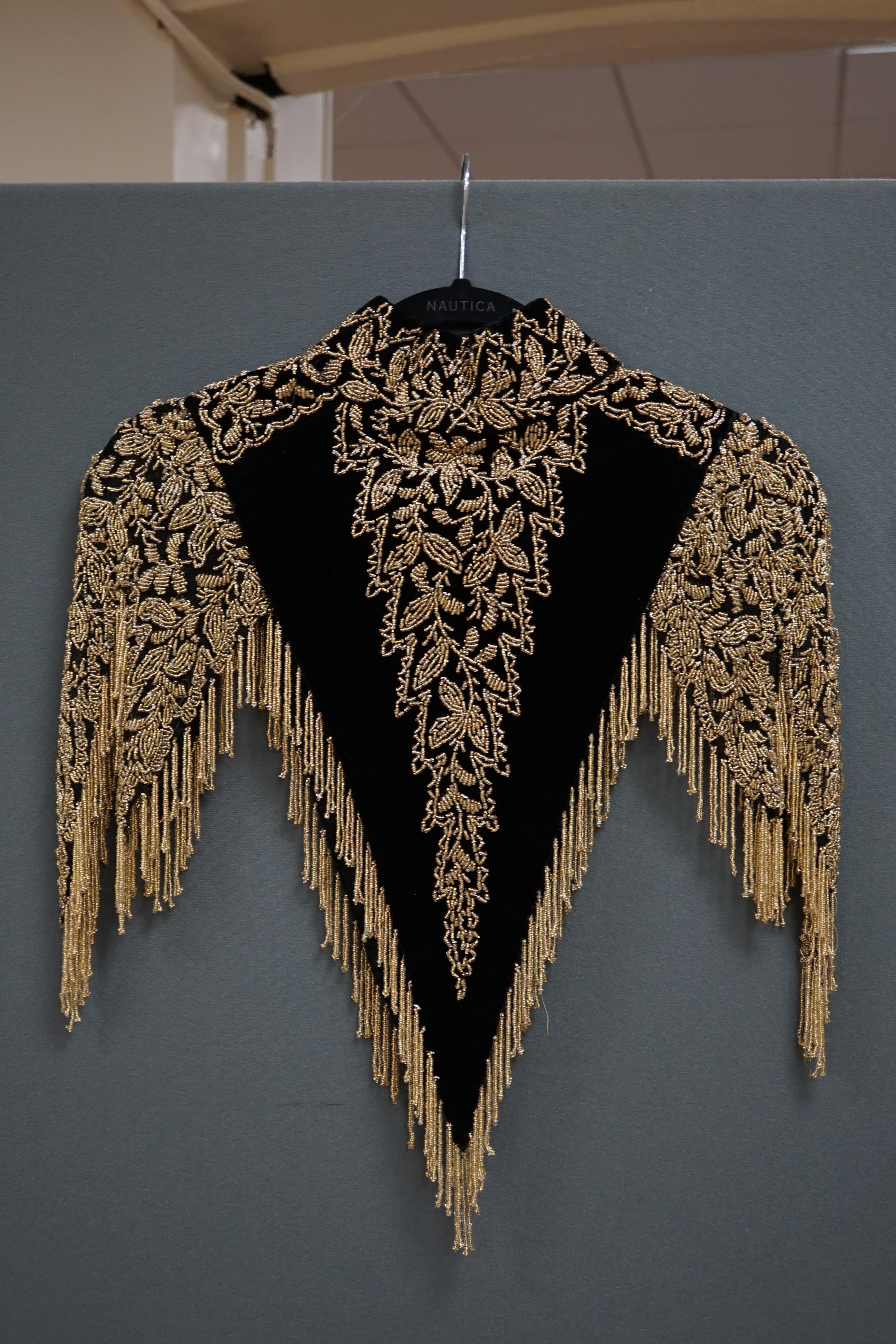 An Edwardian French black velvet and elaborately beaded evening over collar, with makers label, ‘Fillet’, designed with a high collar, front and back panels, all heavily bead worked in an intricate floral design, attache